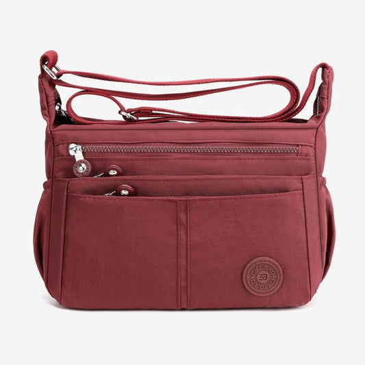 Bolso bandolera informal impermeable de gran capacidad y múltiples bolsillos.